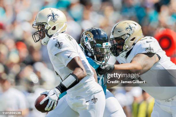 Teddy Bridgewater of the New Orleans Saints is pressured by Abry Jones of the Jacksonville Jaguars during the first quarter of a game at TIAA Bank...