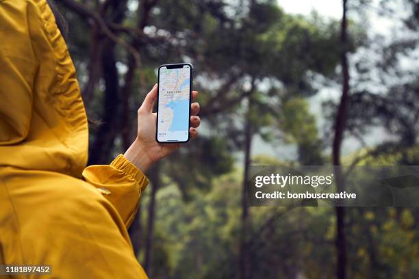 de kaart controleren op iphone x in forrest - holding iphone stockfoto's en -beelden