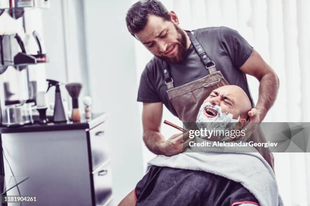 barber macht einen fehler und schneidet männlichen kunden mit rasiermesser - safety shave razor stock-fotos und bilder