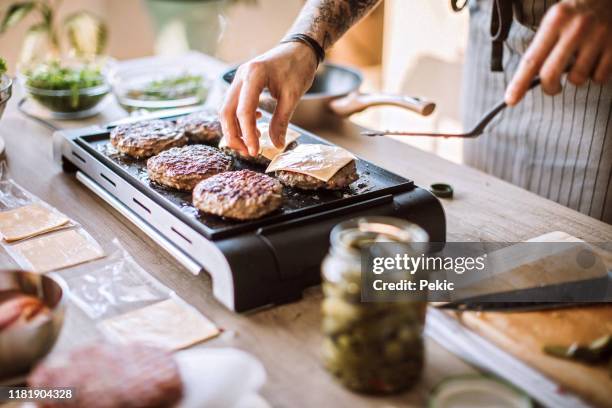 zelfgemaakte cheeseburgers zijn specialiteit - barbecue huishoudelijk apparaat stockfoto's en -beelden