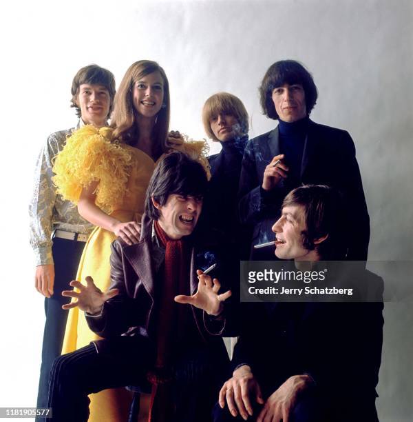 Portrait of the members of English rock group the Rolling Stones poses with an unidentified woman in a yellow dress, New York, New York, February 12,...