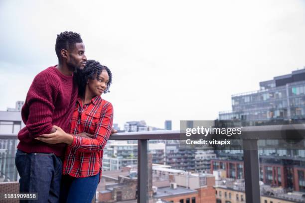 couple enjoying their balcony view - toronto condo stock pictures, royalty-free photos & images