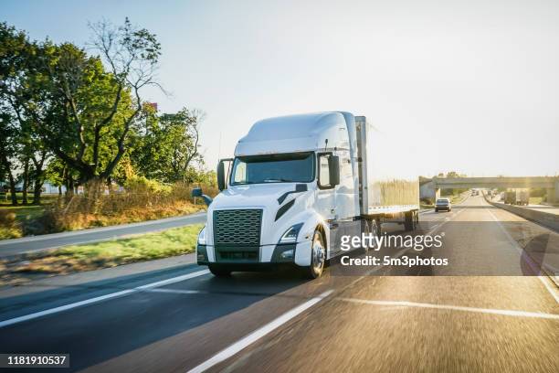 semi truck concept 18 wheeler delivering freight on the highway at sunset - 2019 truck stock-fotos und bilder