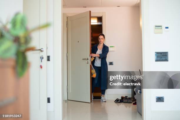 frau kommt nach lebensmitteleinkauf nach hause - coming home front door stock-fotos und bilder