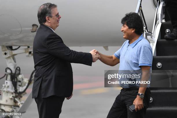 Mexican Foreign Minister Marcelo Ebrard shakes hands with Bolivian ex-President Evo Morales upon his arrival in Mexico City, on November 12 where he...