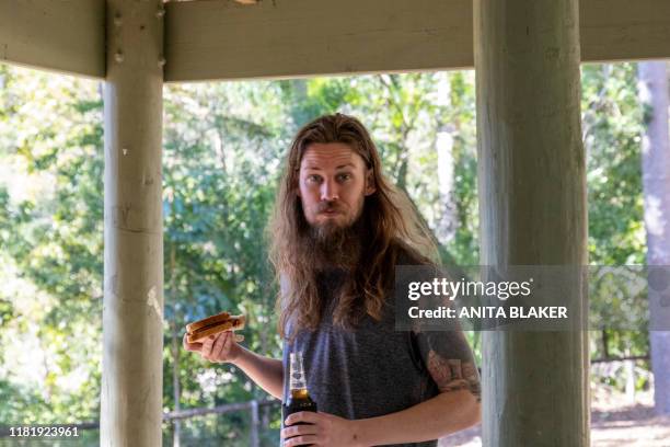 single male at a party bbq in the park - barbecue man stock pictures, royalty-free photos & images