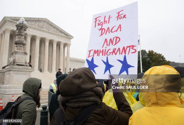 Immigration rights activists hold a rally in front of the US Supreme Court in Washington, DC, November 12 as the Court hears arguments about ending...