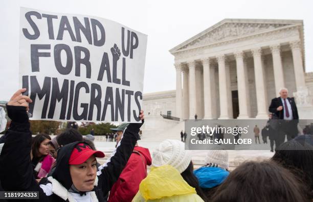 Immigration rights activists hold a rally in front of the US Supreme Court in Washington, DC, November 12 as the Court hears arguments about ending...