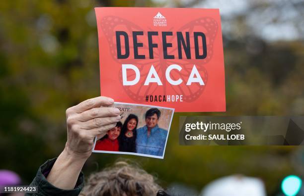 Immigration rights activists hold a rally in front of the US Supreme Court in Washington, DC, November 12 as the Court hears arguments about ending...