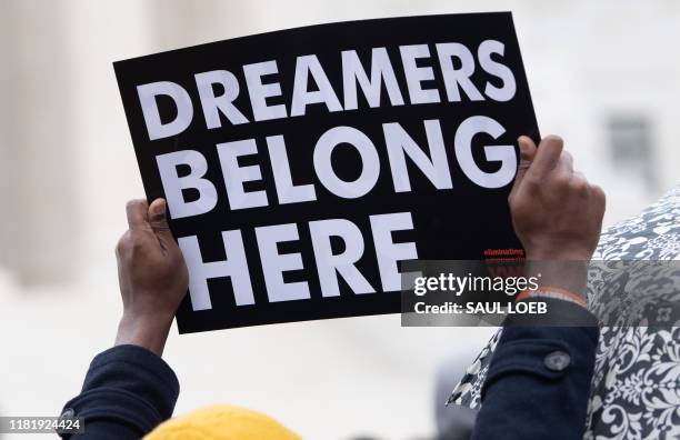 Immigration rights activists hold a rally in front of the US Supreme Court in Washington, DC, November 12 as the Court hears arguments about ending...