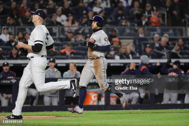 George Springer of the Houston Astros scores a run off of a wild pitch thrown by James Paxton of the New York Yankees during the first inning in game...