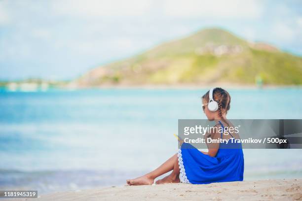 little adorable girl listening music background sea - radio antigua stock pictures, royalty-free photos & images