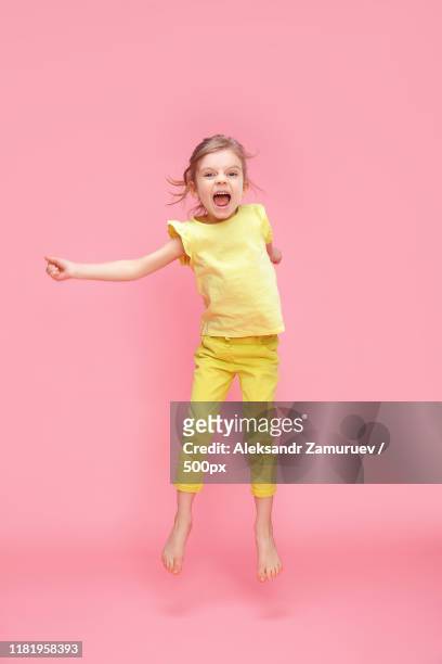 excited girl jumping in studio - charmig bildbanksfoton och bilder