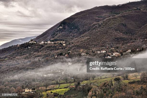 scenic view of village in mountains - raffaele corte stockfoto's en -beelden