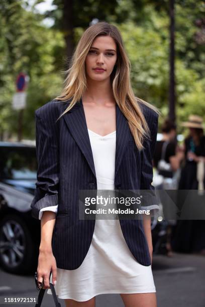 Model Noel Berry wears a navy pinstripe blazer and white silk slip dress after the Redemption show during Couture Fashion Week Fall/Winter 2019 on...