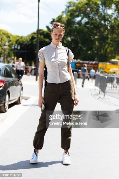 Model Natalie Ogg wears a white shirt, green pants, and white sneakers after the Chanel show during Couture Fashion Week Fall/Winter 2019 on July 02,...