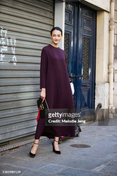 Supermodel Ai Tominaga wears a purple dress and carries a black Valentino bag after the Valentino show during Couture Fashion Week Fall/Winter 2019...