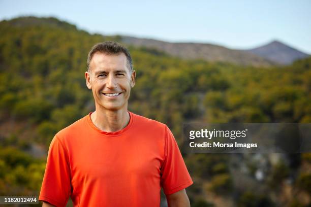 portrait of smiling mature man against mountain - mature men imagens e fotografias de stock
