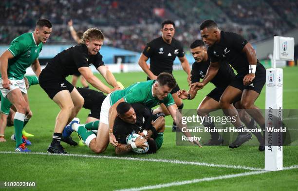 Aaron Smith of New Zealand scores his team's second try past Conor Murray and Jacob Stockdale of Ireland during the Rugby World Cup 2019 Quarter...