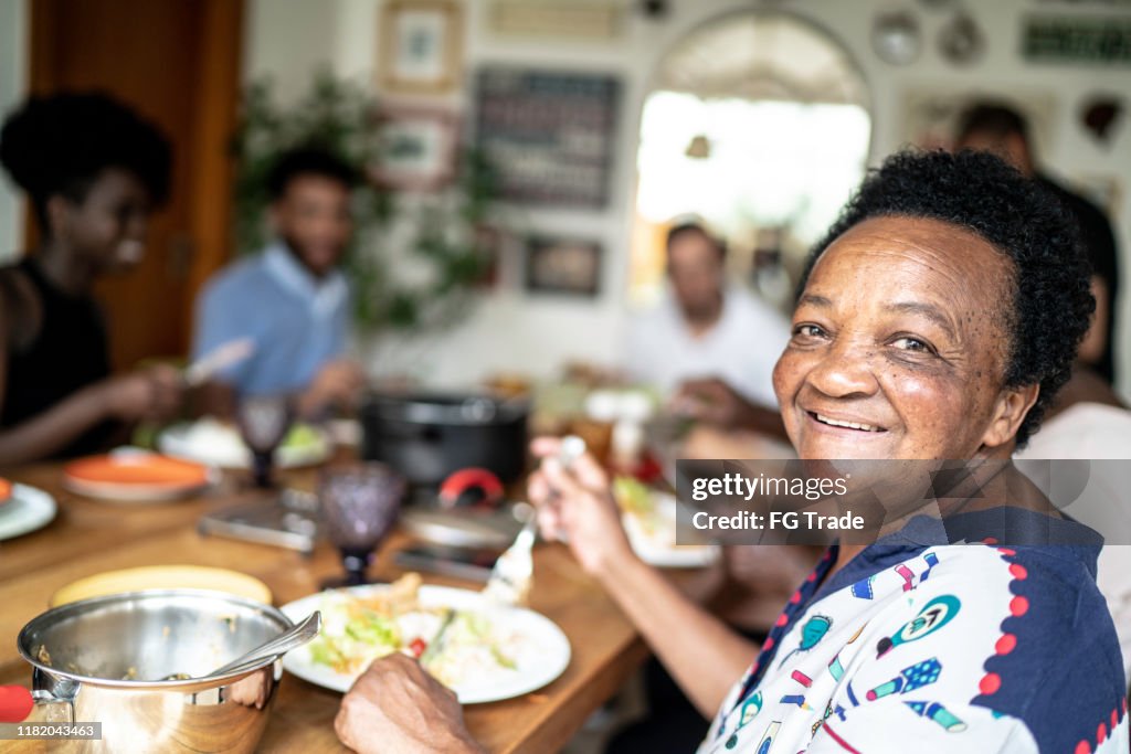 老年婦女吃飯和看相機的肖像