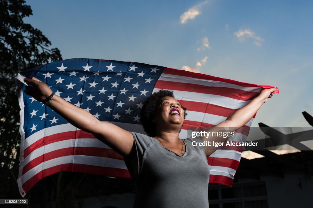 Proud woman raising the flag of the United States of America