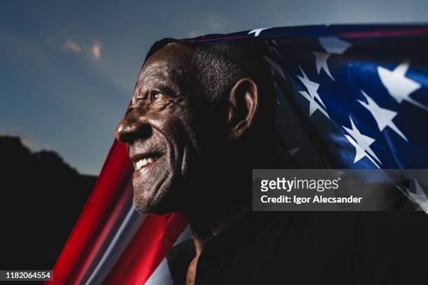 homme fier soulevant le drapeau des etats-unis d'amérique - cérémonie du drapeau photos et images de collection