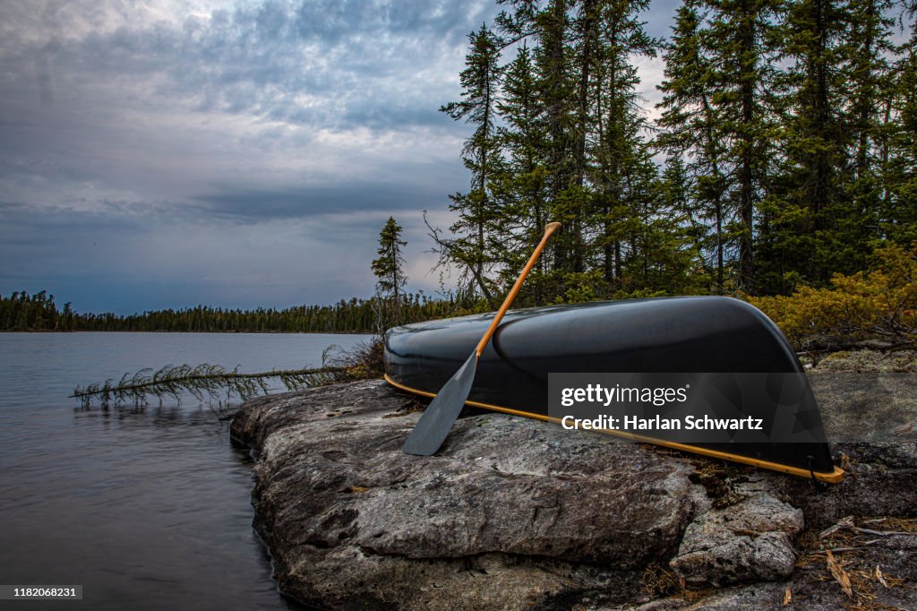 Canoe on shore with storm approaching.