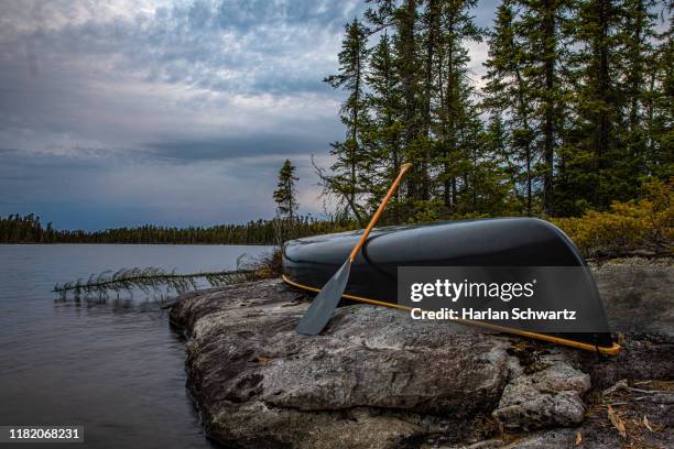 canoe on shore with storm approaching. - minnesota lake stock pictures, royalty-free photos & images