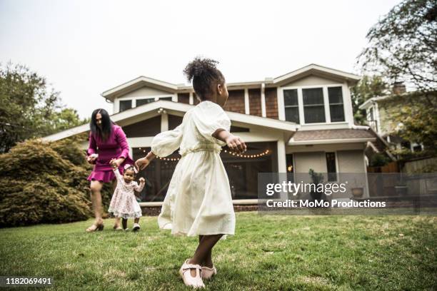 Young girl (3 yrs) playing in backyard