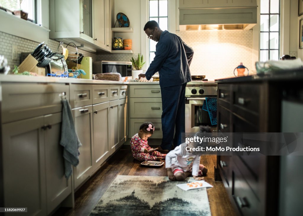 Father cooking breakfast for daughters in kitchen