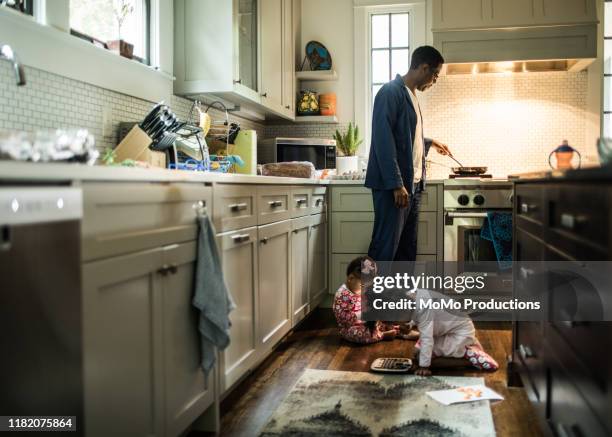 father cooking breakfast for daughters in kitchen - single father - fotografias e filmes do acervo