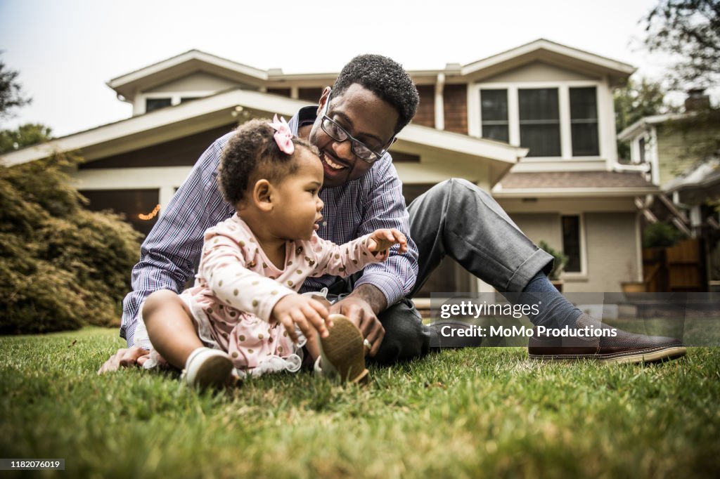 Father and daughter (18 months) playing in backyard