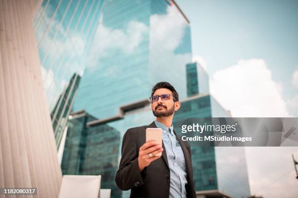 businessman near skyscrapers - below stock pictures, royalty-free photos & images