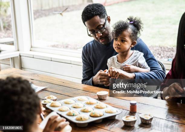 Father and daughter (3yrs) making cupcakes at playdate