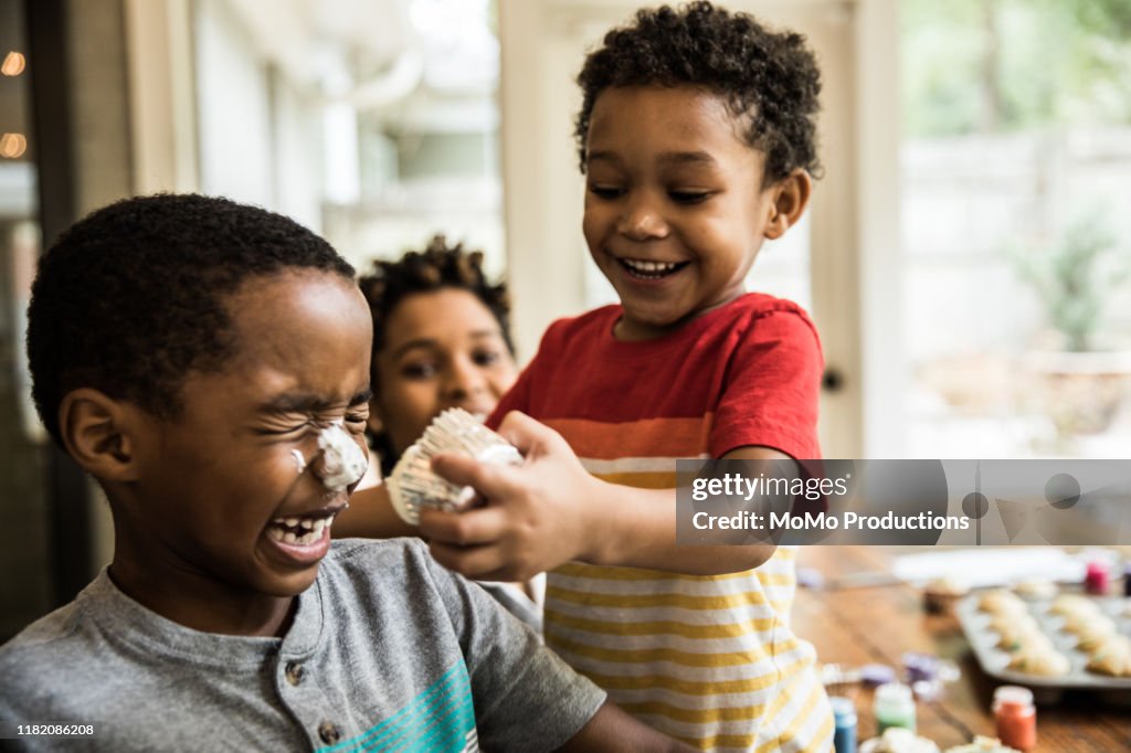 Young boys with cake frosting on faces at party