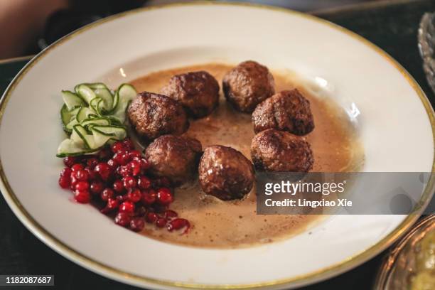 famous swedish meatballs with lingonberries and slices of cucumber in gravy sauce, stockholm, sweden - swedish culture fotografías e imágenes de stock