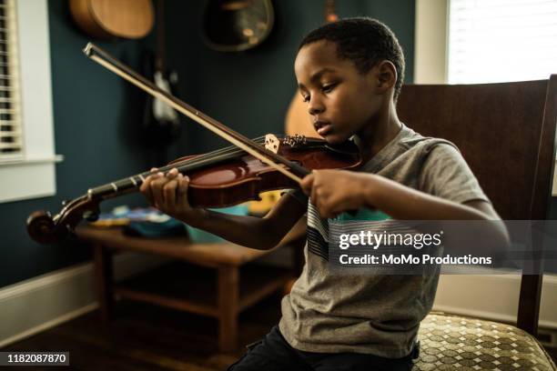 young boy (6 yrs) practicing violin - playing music photos et images de collection