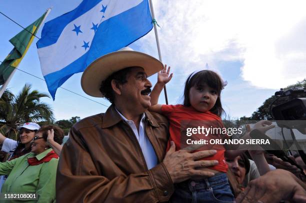 Ousted Honduran President, Manuel Zelaya holds his granddaughter at the Brazilian Embassy in Tegucigalpa on September 21, 2009. Zelaya made a...