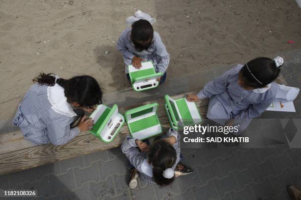 Palestinian schoolchildren inspect new laptops at a school in Rafah, in the southern Gaza Strip, on April 29, 2010. The UN agency for Palestinian...