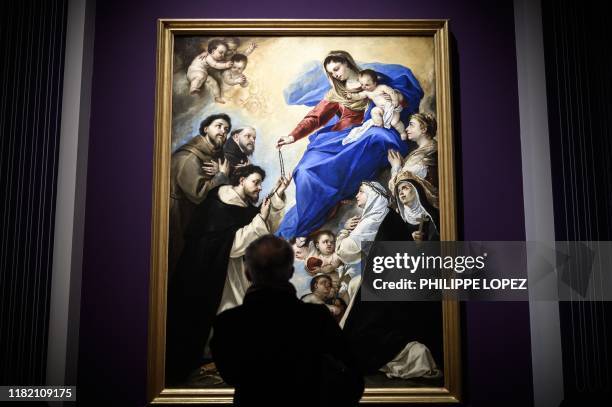 Man looks at the painting 'Our Lady of the Rosary' as he visits the exhibition "The Triumph of the Neapolitan painting" consisting of the first ever...