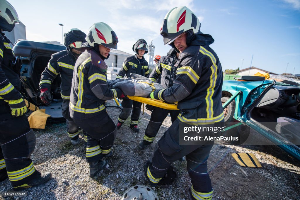 Feuerwehrleute bei einer Rettungsaktion bei einem Autounfall mit dem Opfer