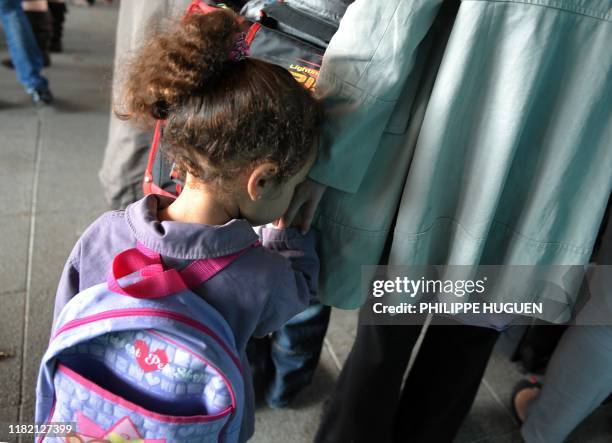 Une jeune enfant tient la main de sa maman, le 05 septembre 2011 à l'école élementaire Moulins-Pergaud à Lille, lors de la rentrée scolaire Plus de...