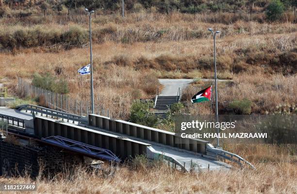 General view shows the Jordanian and Israeli flags on either side of a bridge, spread across the border between the two contries, in the Jordan...