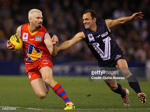 Tony Liberatore of Victoria attempts to tackle Jason Akermanis of the All Stars during the E.J Whitten Legends Game at Etihad Stadium on July 5, 2011...