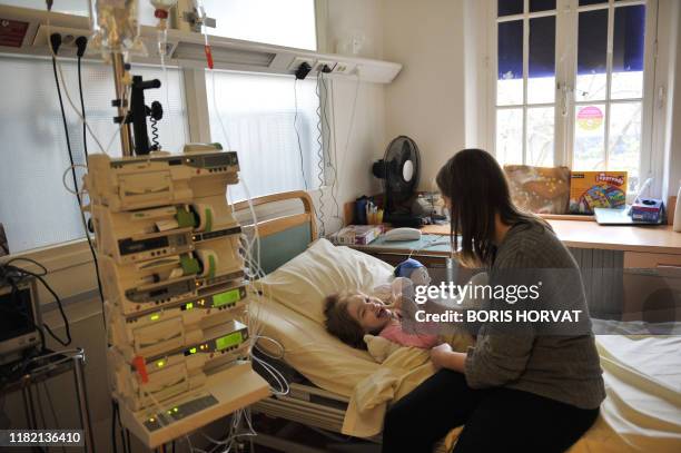 Anne-Laure de la Rochette présente à sa fille Itea, "Plume", une poupée, le 18 novembre 2010 au centre de gastroentérologie de l'hôpital Necker à...