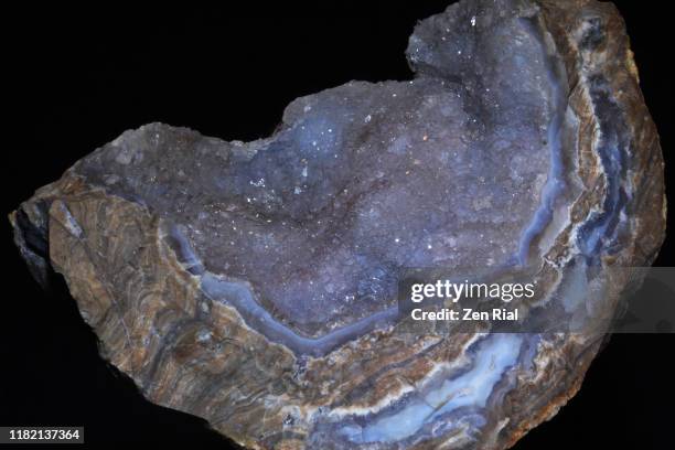 sparkling crystals inside a broken geode against black background - geode stock pictures, royalty-free photos & images