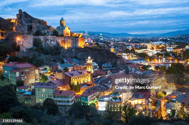 dusk settles over tbilisi's old town and narikala fortress.  tbilisi, georgia - georgian stock-fotos und bilder