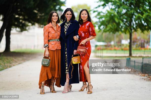 Camila Coelho wears earrings, a necklace, an orange quilted safari jacket, an almond-green belt, an almond-green crocodile pattern Chloe handbag, a...