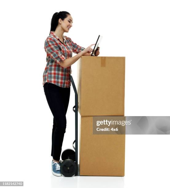 Full length / one person / front view of 18-19 years old adult beautiful black hair / long hair / ponytail caucasian female / young women delivery person / manual worker standing in front of white background who is smiling / happy / cheerful