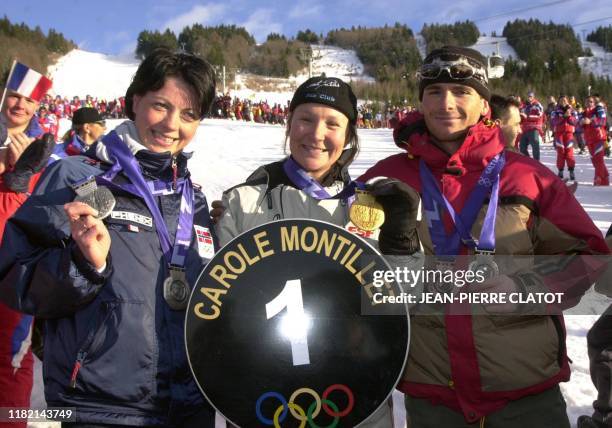 La skieuse française Carole Montillet, championne olympique de descente à Salt Lake City, présente sa médaille d'or au public, en compagnie de...